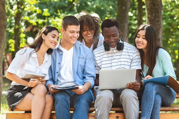 Estudiantes Passtime. Amigos universitarios sentados al aire libre con computadora portátil, viendo videos juntos — Foto de Stock