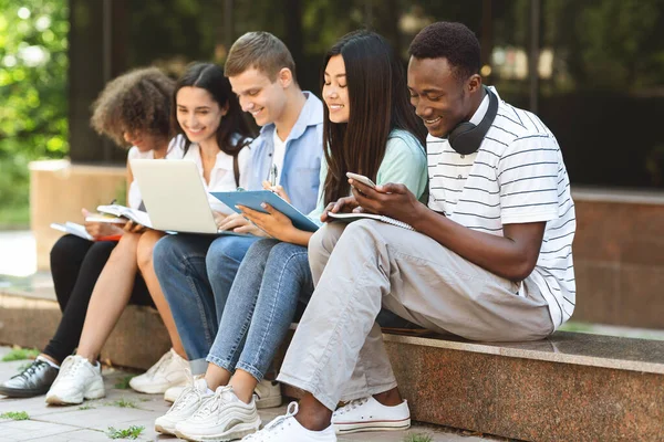 Conceito de educação. Estudantes universitários se preparando para o exame ao ar livre, falando e sorrindo — Fotografia de Stock