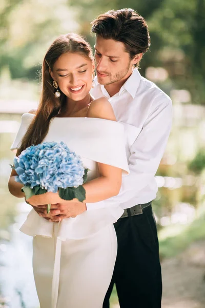 Gerade verheiratetes Paar umarmt stehend draußen, vertikaler Schuss — Stockfoto