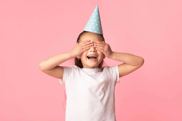 Šťastná asijská dívka zakrývající si oči, nošení klobouku — Stock fotografie