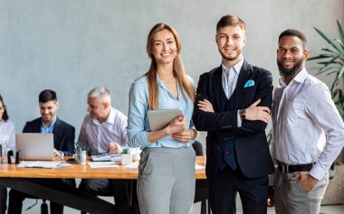 Modern Ofiste Kameraya Gülümseyen Üç İş Ortağı
