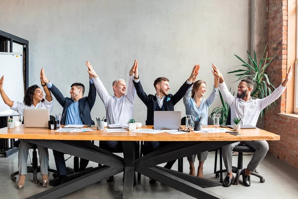 Boldog munkatársak, akik pacsiznak és örülnek a sikernek az irodában — Stock Fotó