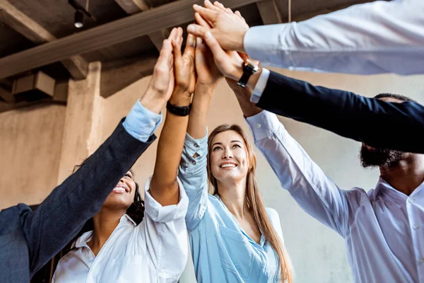 Colleagues Giving High-Five Celebrating Business Success Standing In Office  Stock Photo by ©Milkos 381522740