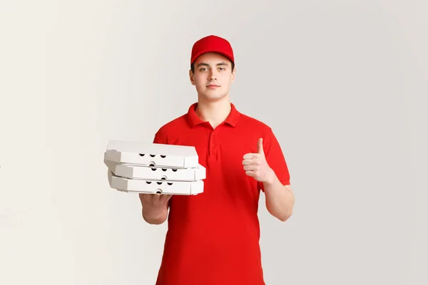La mejor entrega de comida. Courier sostiene cajas de pizza y muestra el cartel perfectamente con su mano — Foto de Stock