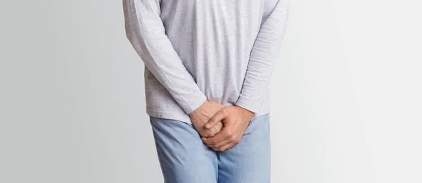 Male diseases. Man presses hands to his groin and suffering from pain — Stock Image Male diseases. Man presses hands to his groin and suffering from pain Royalty Free Stock Images