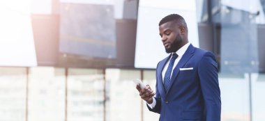 Şehirde Yürüyen İş Uygulamalı Akıllı Telefon kullanan İşadamı, Panorama