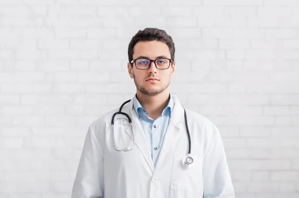 Online conference and doctor presentation. Man with stethoscope on a white wall background