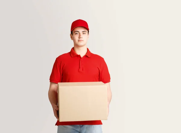 Post trabajador emite paquete. Courier sostiene una caja grande de cartón — Foto de Stock