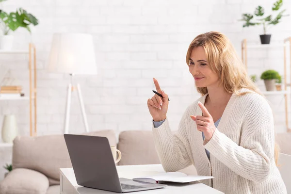 Nauczyciel online. Kobieta posiada lekcję dla studenta na laptopie w salonie — Zdjęcie stockowe