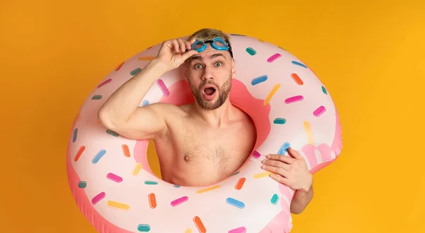 Guy in inflatable ring takes off glasses for swimming — Stock Photo, Image