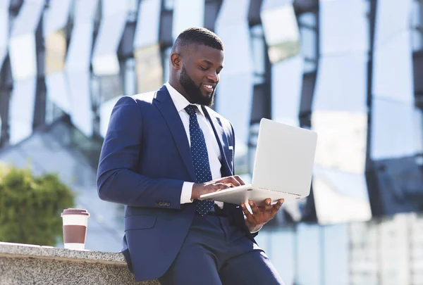 Ευτυχισμένος αφρικανικός αμερικανός επιχειρηματίας χρησιμοποιώντας το lap-top κατά τη διάρκεια διαλείμματος καφέ — Φωτογραφία Αρχείου