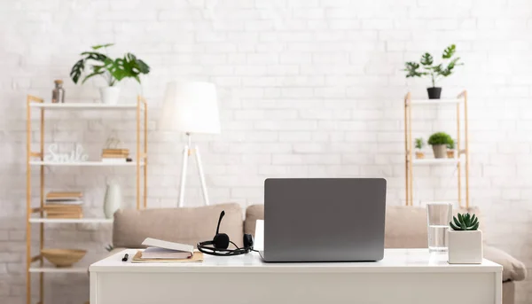 Stanza di lavoro a casa. Computer portatile e cuffie sul tavolo in interni — Foto Stock