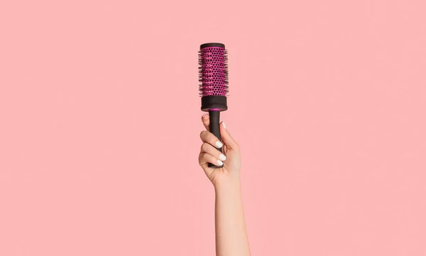 Gesneden weergave van meisje met haarborstel op roze achtergrond, close-up — Stockfoto
