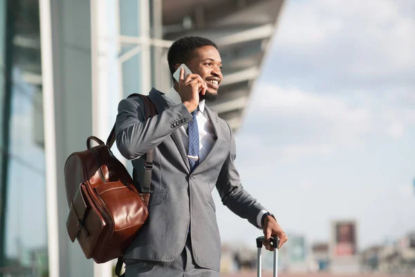 Podnikatel s telefonem konverzace stojící s kufrem v blízkosti železniční stanice — Stock fotografie