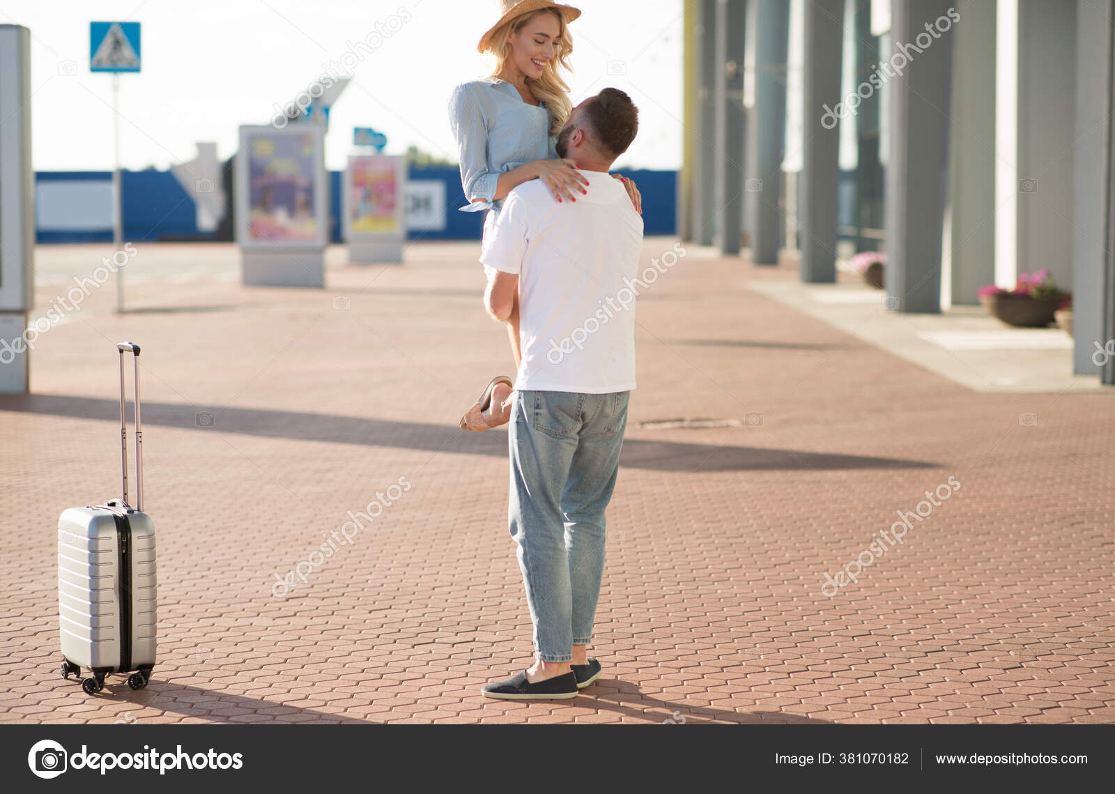 Boyfriend picking up his girlfriend near airport building Stock Photo