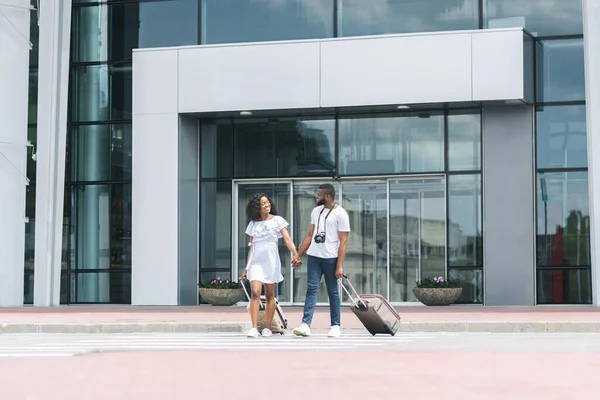 Endlich nach Hause. Glückliche schwarze Eheleute verlassen gemeinsam Flughafen-Terminal — Stockfoto