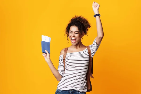 Happy Traveler Girl wstrząsające pięści pozowanie z biletów, żółte tło — Zdjęcie stockowe