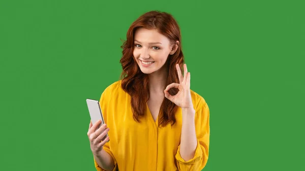 Millennial Girl Usando Smartphone Gesturing Ok no fundo verde, Panorama — Fotografia de Stock