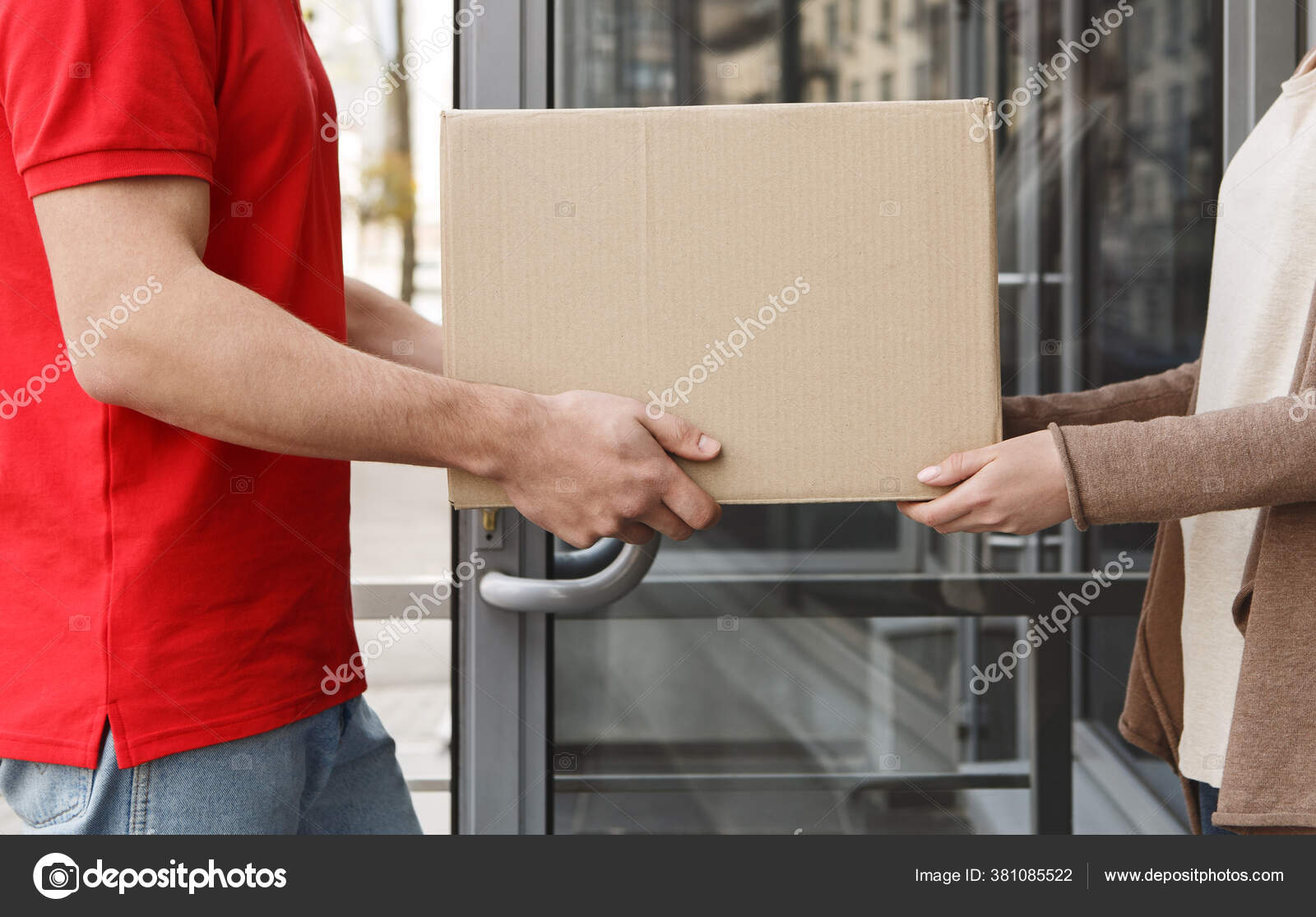 Transfer of parcels from hand to hand. Courier and girl hold cardboard