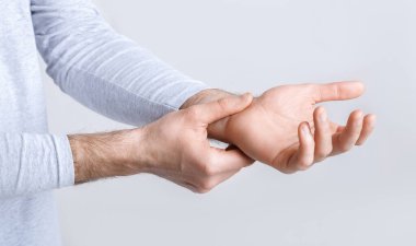 Karpal tünel sendromu ve bilek ağrısı. Adam hassas noktaya tutunuyor.