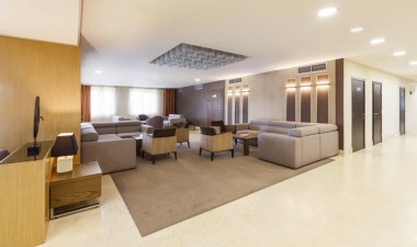Otelde büyük gri koltukları ve koltukları olan bir salon.