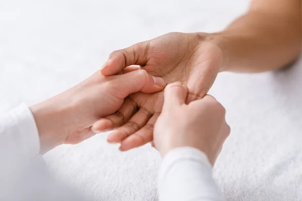 Close-up de terapeuta massageando mão mulher negra — Fotografia de Stock