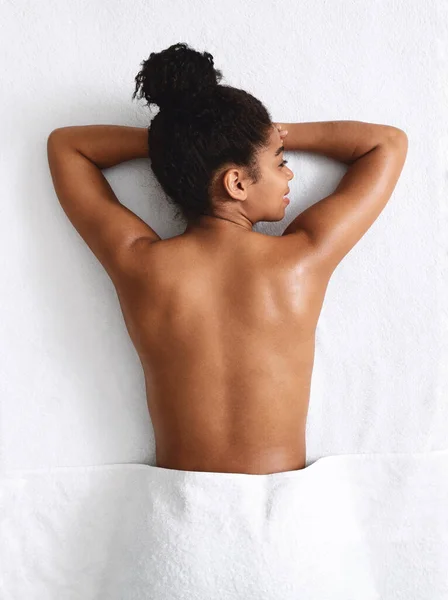 Mince fille noire couchée, prête pour le massage du dos — Photo