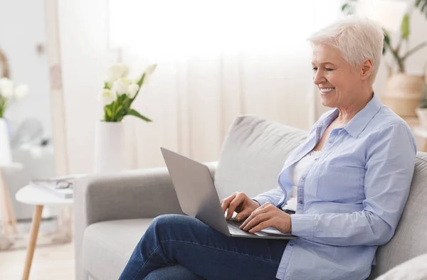 Empregos Freelance para Idosos. Sorrindo idosa senhora trabalhando no laptop em casa — Fotografia de Stock