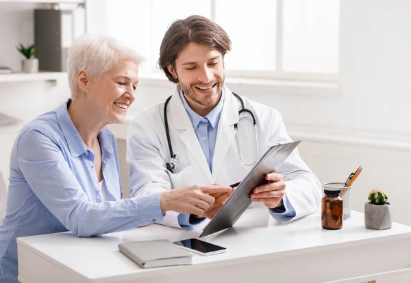 Médico mostrando recomendaciones a paciente mayor — Foto de Stock
