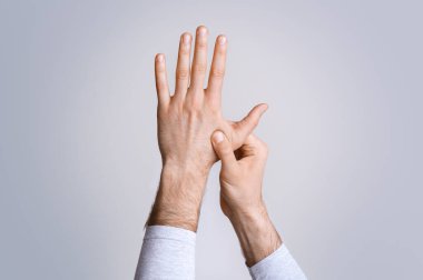 Artrit ve parmak ağrısı. Adam hassas noktaya baskı yapıyor, stüdyo çekimi.