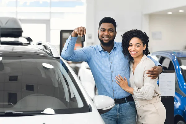 Cheerful African Spouses Holding Car Key Standing In Dealership Center — Stock Photo, Image