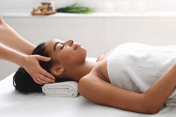 Beautiful african woman visiting spa, having head massage — Stock Photo, Image