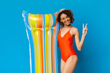 Yüzen eğlence. Renkli Şişirilebilir Yatağı Olumlu Afro Kız Havuz kenarında Serinliyor