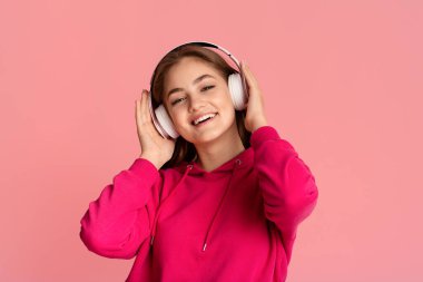 Rahatlayın ve müzik. Kablosuz kulaklıklı genç kız favori şarkının tadını çıkarıyor.