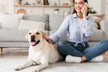 Güzel bir genç kadın ve köpeğinin portresi cep telefonu kullanıyor.