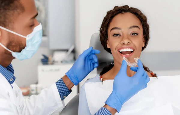 Dentist applying invisible aligner on female patient teeth — Stock Photo, Image