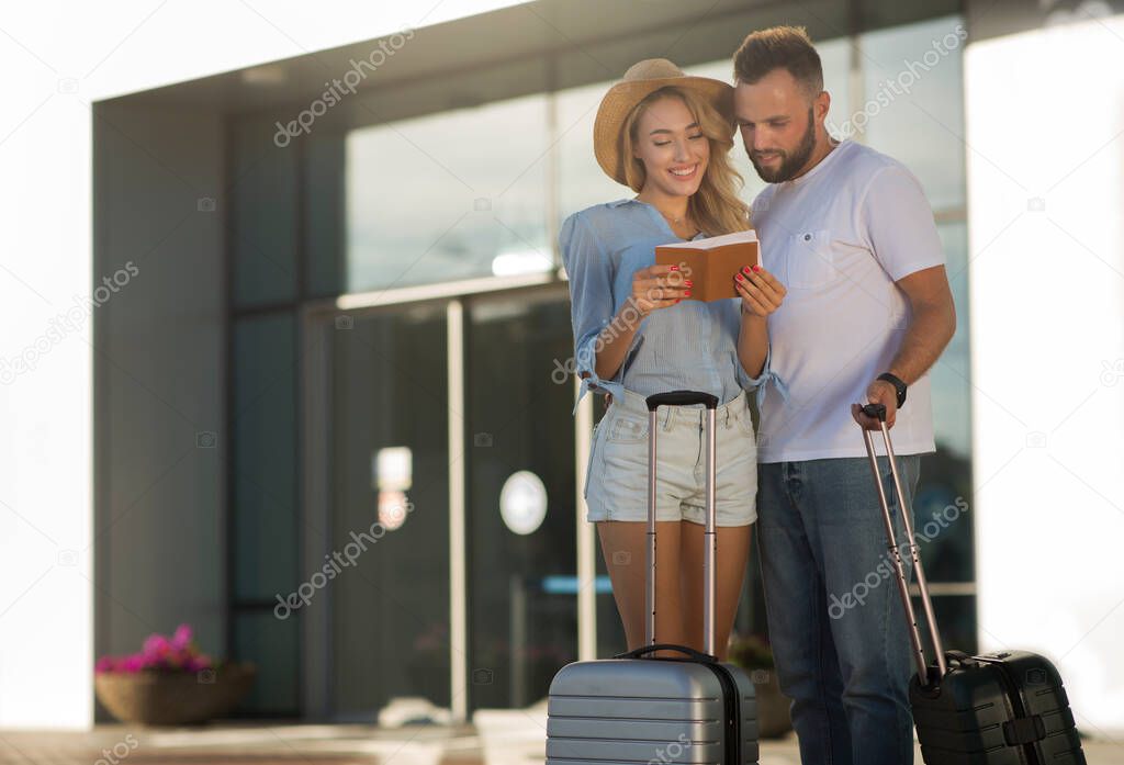 Travel concept. Couple checking tickets near airport