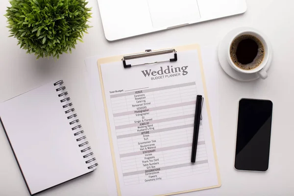Büroarbeitsplatz mit Hochzeitsplaner und anderen Dingen — Stockfoto