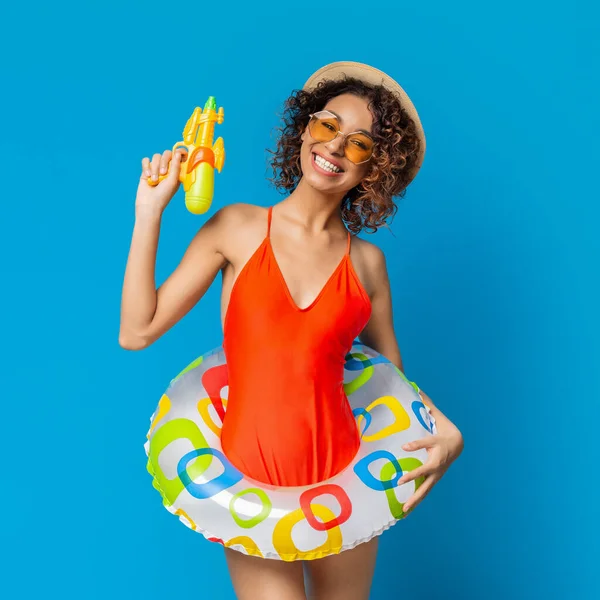 青い背景の上にビーチおもちゃで遊んで水着でアフリカの女の子を笑顔 — ストック写真