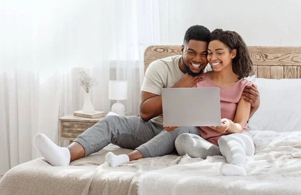 Verliebtes Paar schaut Fotos auf Laptop im Schlafzimmer — Stockfoto