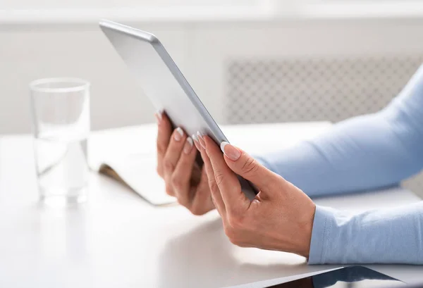 Online conference. Middle aged women hands holds tablet on white table — Stock Photo, Image