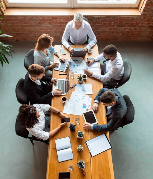 Business Colletes Working Using Gadgets Sitting In Modern Office, Above-View — стокове фото