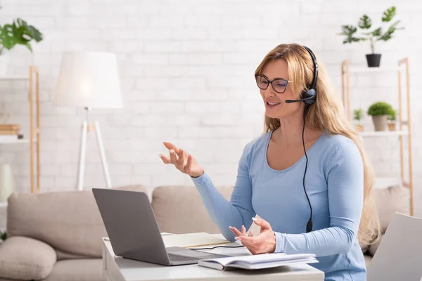 Kundenbetreuung aus der Ferne. Frau mit Headset und Laptop am heimischen Arbeitsplatz — Stockfoto