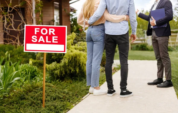 Ausgeschnittene Ansicht von Millennial-Paar und Immobilienmakler in der Nähe Haus zu verkaufen, im Freien — Stockfoto