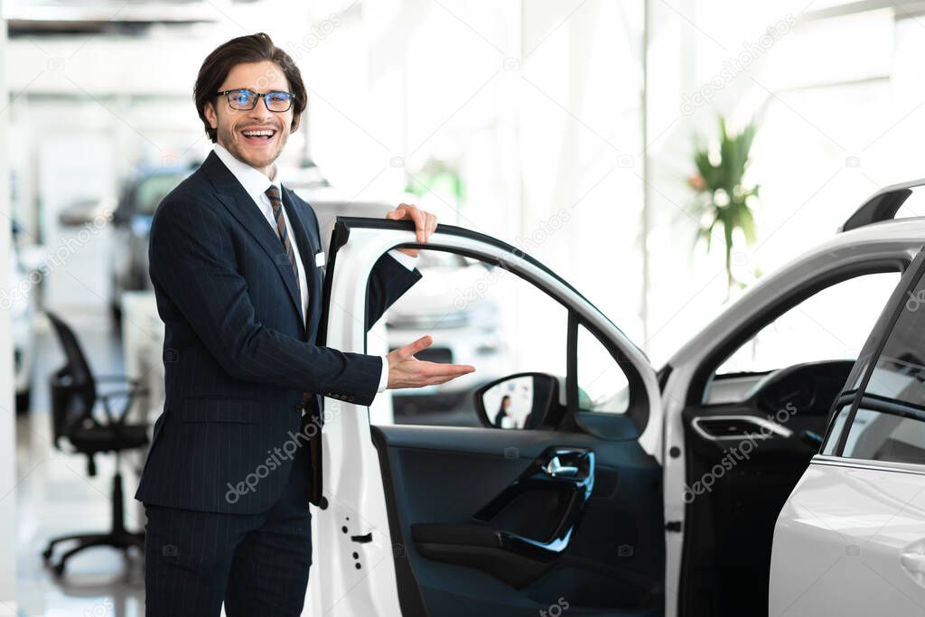 Dealer Showing New Automobile Opening Door For Customer