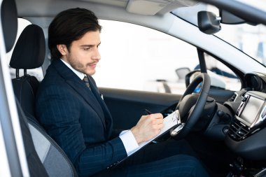 Oto Satıcısı Otomatikde Oturup Satıcılıkta Not Alıyor