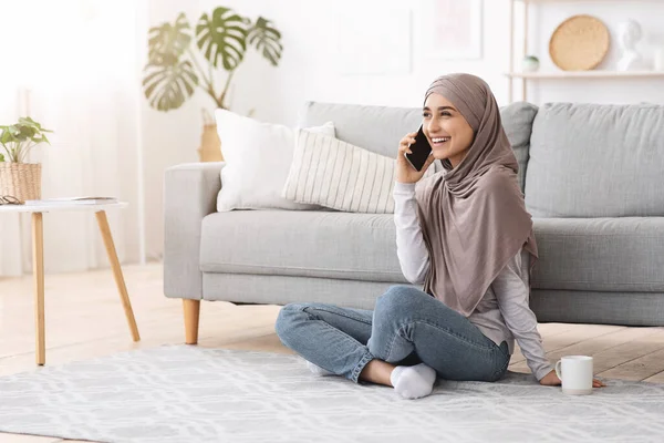 Waktu luang. Joyful Muslim Girl Talking On Cellphone With Friend At Home — Stok Foto