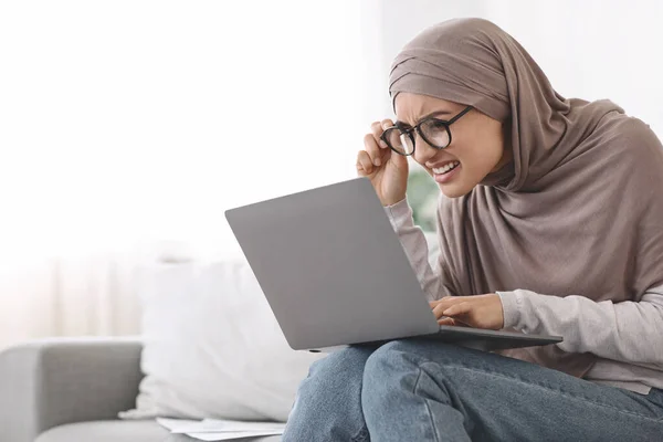 Problemas de vista. Mujer en Hijab entrecerrar los ojos mientras mira la pantalla del ordenador portátil — Foto de Stock