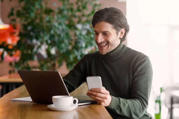 Empresario emocional que trabaja en línea, utilizando el ordenador portátil y el teléfono inteligente — Foto de Stock