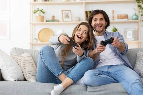 Casal competitivo jogando jogos de vídeo em casa — Fotografia de Stock